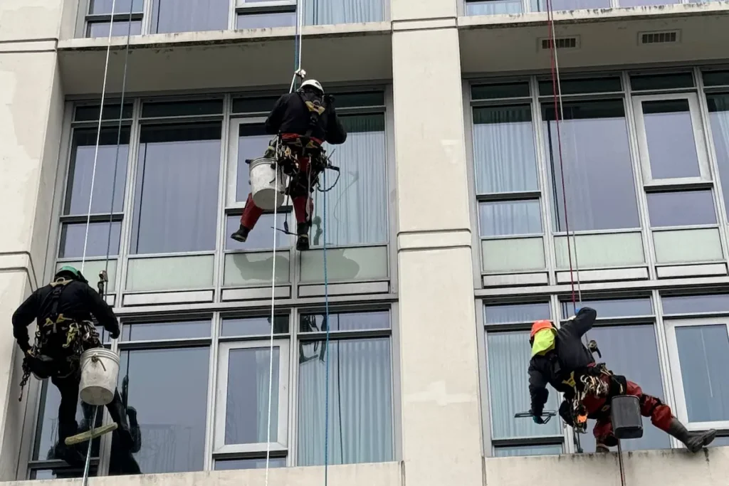Rope access team cleaning windows in a high rise